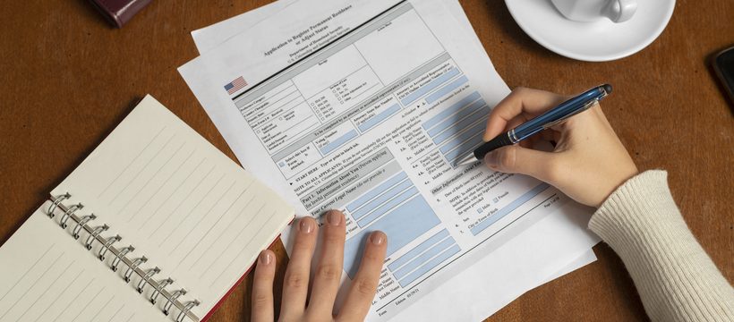 Tax professional reviewing IRS forms by hand at a desk